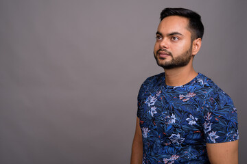 Obraz premium Young bearded Indian man against gray background