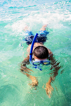 Boy (10-11) snorkeling in sea