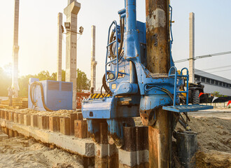 Hydraulic vibratory hammer driven machine pressing retaining wall steel sheet pile for protection...