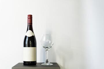 Studio shot of a wine glass and bottle that is unlabeled for your brand. Wine accessory on a stand against white background