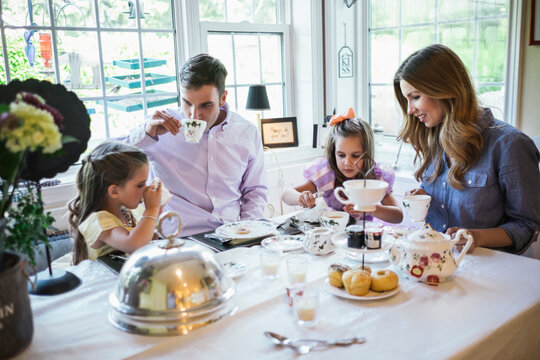 Parents and daughter (4-5) eating together in dining room