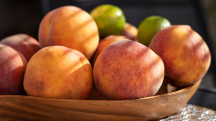 Fruit in a wooden bowl. Peach and lime on the table. Close-up.