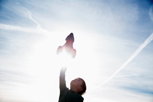 Boy (6-7) playing with toy rocket