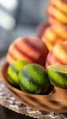 Fruit in a wooden bowl. Peach and lime on the table. Close-up.