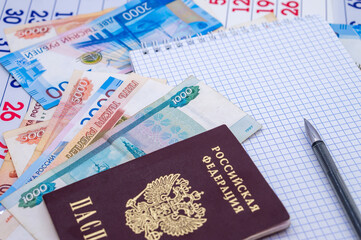 Russian passport on paper money. Notepad and pen on Russian banknotes.