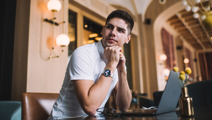 Pensive man having break in working process with laptop