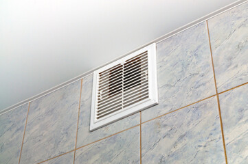 close - up of the ventilation grate on the tile wall