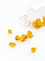 Yellow color fish oil capsules with glass bottle on white background