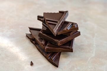 Dark chocolate bar pieces on marble table