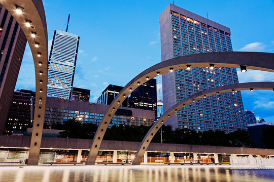 Arches over ice rink and skyscrapers against sky