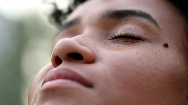 Black woman looking to sky in meditation. African woman closing eyes meditating
