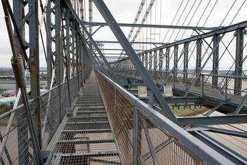 Pedestrian walkway and steel structure on top of the Newport Transporter Bridge as it crosses the River Usk - it is one of only several such bridges in the world.