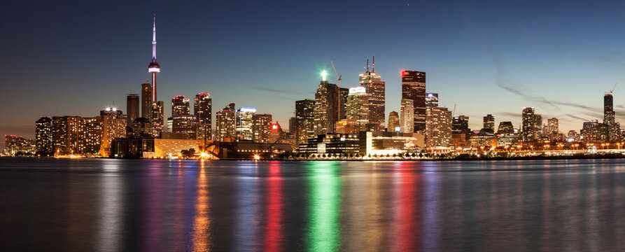Illuminated waterfront skyline reflecting in Lake Ontario
