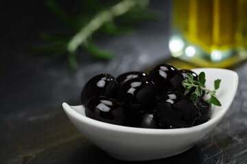 Schwarze Oliven n Schälchen und Olivenöl 