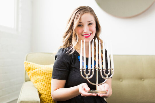 Portrait of young woman holding menorah