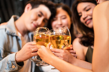 Group of Asian young people hold wine glass and clink glasses in party