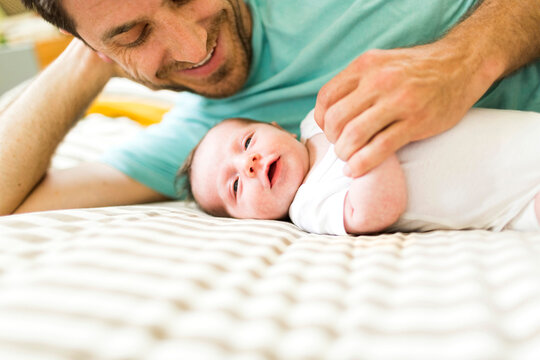 Father With Baby Boy (6-11 Months) On Bed