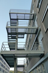 Obraz premium Long set of metal stairs, fire escape route, attached to outside of modern industrial and administrative brick building in Dietikon, Switzerland.
