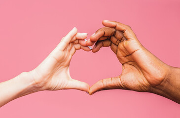 Heart formed by hands caucasian and African American. Diversity concept on pink background. Heart sign with woman and man hands.