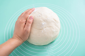 A lump of dough on a silicone kneading mat