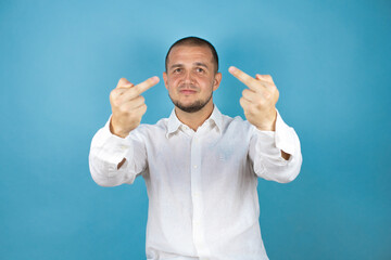 Russian business man over blue background showing middle finger doing fuck you bad expression,...
