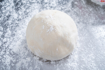 A kneaded dough on a stainless steel chopping board