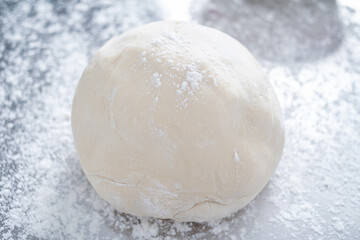 A kneaded dough on a stainless steel chopping board