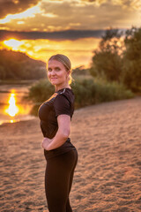 Fit healthy young woman posing at sunset