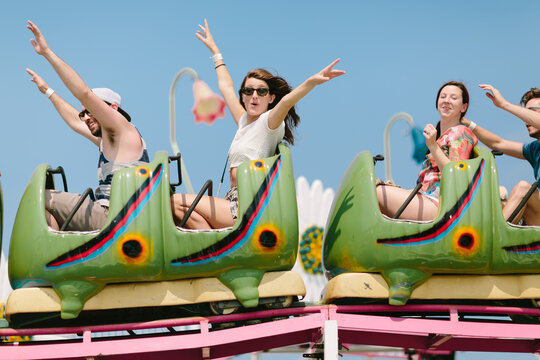 Young friends screaming on a roller coaster ride