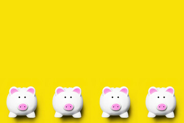 Money diversification background. Four piggy bank isolated on yellow. Home budget planning empty copy space. Coins and banknotes collecting. Cash saving backdrop.