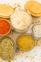 Uncooked dry cereal foods group in glass with wooden lid storage container on white,above view
