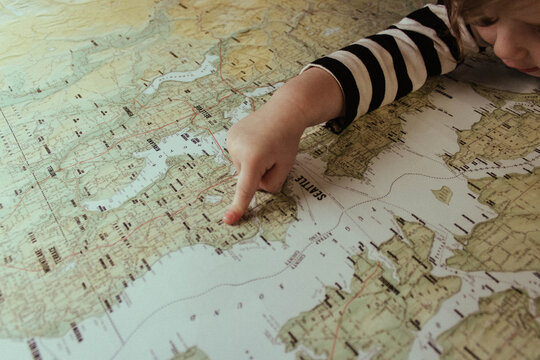 A little girl points to a map