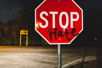 Someone spray painted on a sign, that now says "Stop Hate"