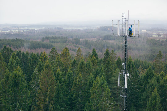 Working at heights, technician climbs up on a communications tower