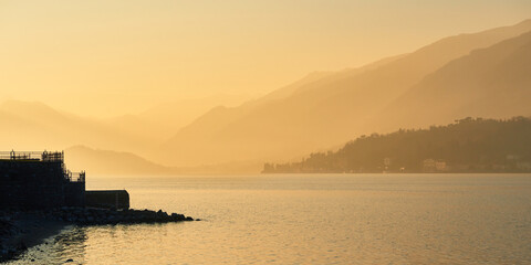 Misty panoramic view of Lake Como and mountains in Italy at sunset in the winter season.