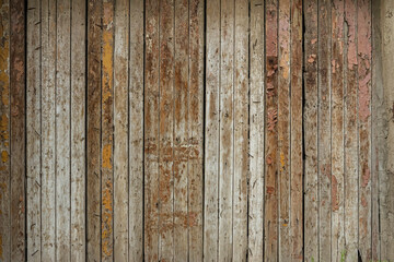 Wooden boards. Grunge texture of wooden boards. Abstract wooden background. The rough texture of the raw wood. Old fence made of wooden boards. Deep cracks. Remains of old paint on the boards
