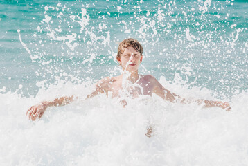 Teenage boy having fun in waves of Atlantic Ocean