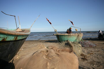 Fishermen repairing nets on a boat trip out to sea in the afternoon July 31, 2014 at the beach of...