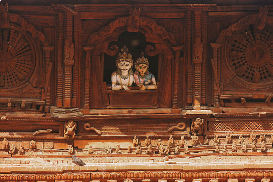 Statues of Shiva and Parbati looking out from a window, in Kathmandu Durbar Square.