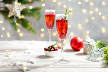 Mimosa festive drink for Christmas - champagne red cocktail Mimosa with cranberry for Christmas party, copy space