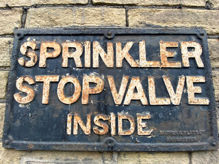 Victorian, Sprinkler Stop Valve Inside, sign, on the wall of a derelict textile mill in, Bradford, Yorkshire, UK