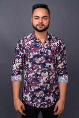 Fototapeta premium Young bearded Indian man against gray background