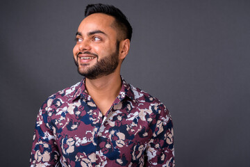 Fototapeta premium Young bearded Indian man against gray background