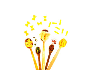 Wooden spoons with pasta and spices on white isolated background