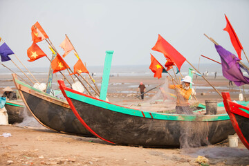 Fishermen repairing nets on a boat trip out to sea in the afternoon July 31, 2016 at the beach of...
