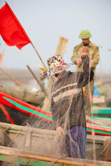 Fishermen repairing nets on a boat trip out to sea in the afternoon July 31, 2016 at the beach of...