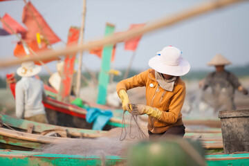 Fishermen repairing nets on a boat trip out to sea in the afternoon July 31, 2016 at the beach of Hai Ly, Vietnam.