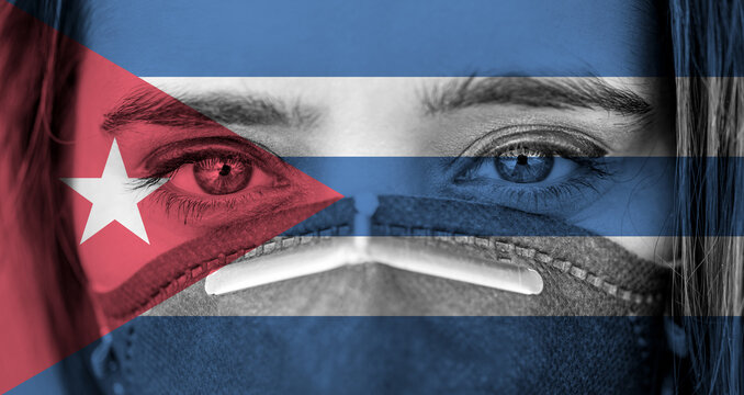 Closeup photo of woman's eyes wearing protective mask against the background of the Cuba flag. 