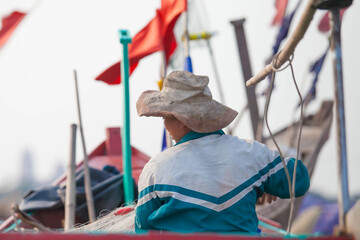 Fishermen repairing nets on a boat trip out to sea in the afternoon July 31, 2014 at the beach of...