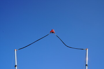 The people entertains herself by jumping on a bungee catapult. The catapult trampoline at the top...